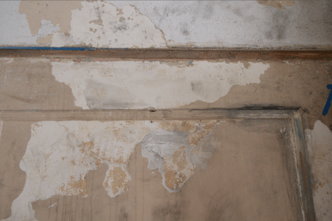 Damaged plaster, filth from the ceiling demo, and splotches of paint stripper.